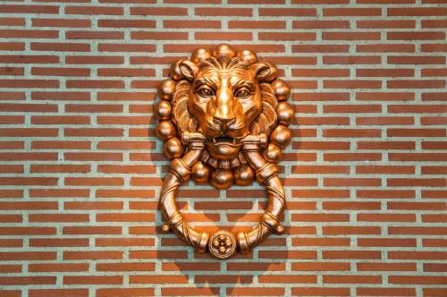 a gold lion statue on a brick wall at Posadas de España Pinto in Pinto
