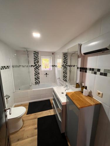 ein Badezimmer mit einem Waschbecken, einem WC und einer Badewanne in der Unterkunft Résidence du Moulin 2-C-2 in Boussu