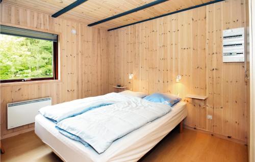 Lønne HedeにあるAmazing Home In Nrre Nebel With 3 Bedrooms, Sauna And Wifiの木製の壁のベッドルーム1室