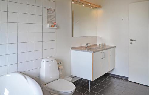 bagno con servizi igienici, lavandino e specchio di 4 Bedroom Lovely Home In Nrre Nebel a Lønne Hede