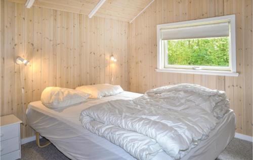 1 dormitorio con 1 cama blanca y ventana en Awesome Home In Oksbl With Sauna, en Oksbøl