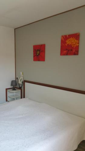 a bedroom with a white bed and two pictures on the wall at Le Magiot in Montliot-et-Courcelles