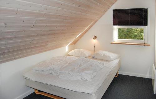 HemmetにあるAmazing Home In Tarm With 5 Bedrooms, Sauna And Wifiの木製の壁のドミトリールームのベッド1台分です。