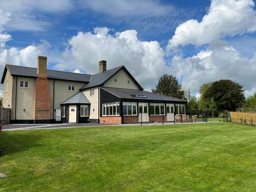 a house with a lawn in front of it at White House Lodges in Heveningham