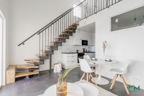 a living room with a staircase and a table and chairs at Kotimaailma - Kaunis ja hyvin valoisa kaksio Vantaalta in Vantaa