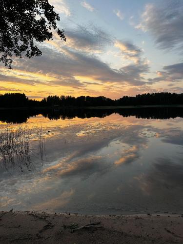a view of a lake at sunset with clouds in the water at Sunset Village in Aglona