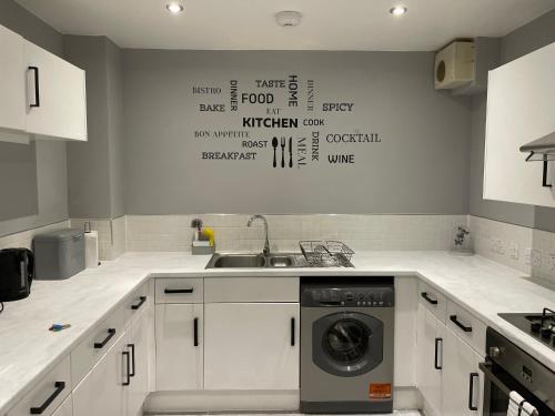 a kitchen with a washing machine in a sink at Perfect Stay for Families & Business in CR2 - with FREE parking & 10mins from East Croydon in Purley
