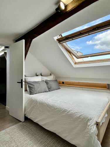 une chambre avec un lit et une grande fenêtre dans l'établissement Perle Rare - Cosy Duplex proche canal St.Martin, à Paris