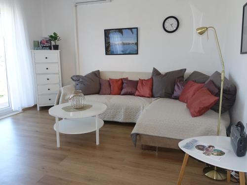 a living room with a couch and two tables at Klimatisiertes Apartment Barbara in Trpanj