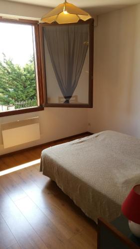 a bedroom with a bed and a large window at Le Magiot in Montliot-et-Courcelles