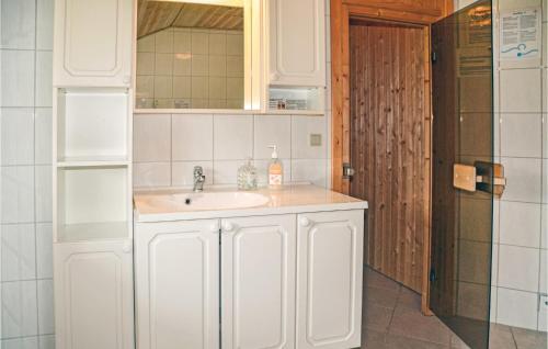 Baño blanco con lavabo y espejo en Gorgeous Home In Oksbl With Kitchen, en Oksbøl