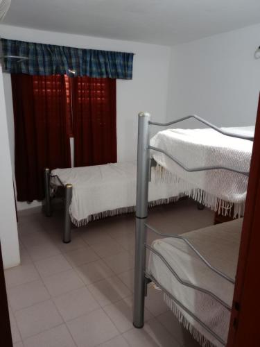 2 camas en una habitación con ventana en Los nidos 2 en Villa Cura Brochero
