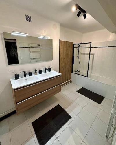 a bathroom with a sink and a mirror and a shower at Convivial appartement de charme avec balcon , 95 m2 en hyper-centre de Saint-Brieuc. Tout confort, grand salon avec vidéoprojecteur - 3 chambres - Parking in Saint-Brieuc