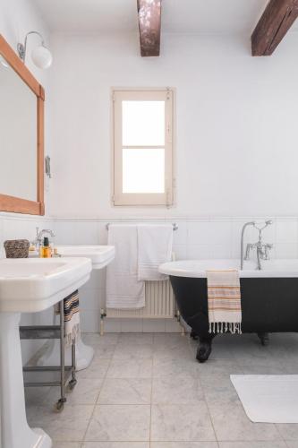 a bathroom with two sinks and a bath tub at CASA SAN ROCCO - Luxurious Grand 18th C. Palace with Gardens & Pool in Hal Ghaxiak