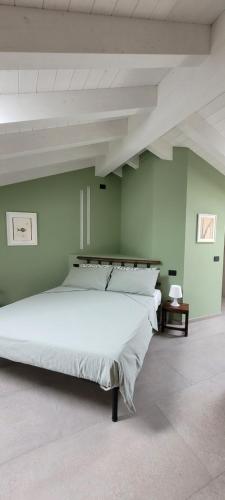 1 cama blanca grande en una habitación con paredes verdes en La Sarmassa, en Vernasca