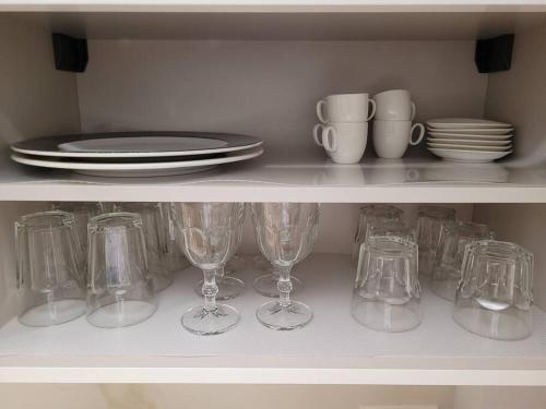 a shelf filled with wine glasses and plates and dishes at Apartamento Azabache in Zaragoza