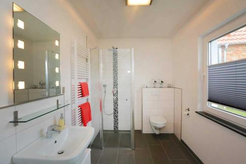 uma casa de banho com um lavatório, um chuveiro e um WC. em Bungalow Mariannenweg 4 em Tarnewitz