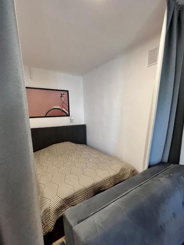 ein kleines Schlafzimmer mit einem Bett und einem TV in der Unterkunft OhMyHome - Hala Mirowska in Warschau