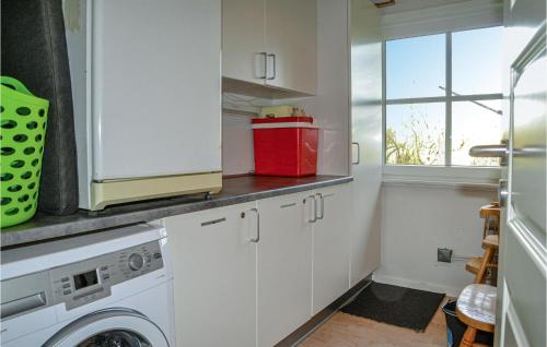 a kitchen with a washing machine and a window at Holiday Home Søndervang Nørre Nebel Ii in Lønne Hede