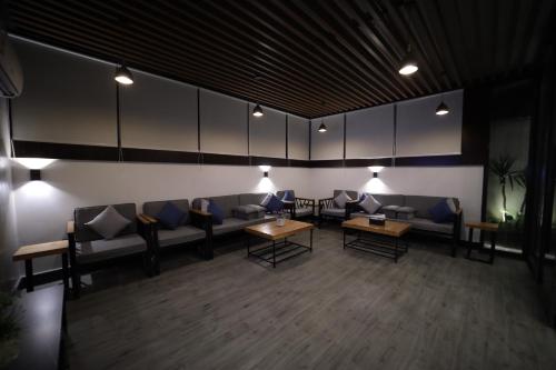 a waiting room with couches and tables and lights at PRIMOTEL Elite As Salamah - Serviced Apartments in Jeddah