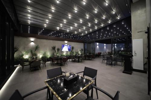 a dining room with tables and chairs and a tv at PRIMOTEL Elite As Salamah - Serviced Apartments in Jeddah