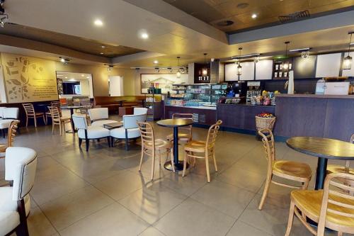 a restaurant with tables and chairs and a counter at Village Hotel Swansea in Swansea