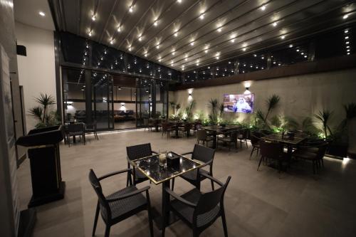 a restaurant with tables and chairs and a flat screen tv at PRIMOTEL Elite As Salamah - Serviced Apartments in Jeddah