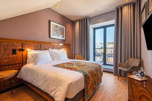 a hotel room with a bed and a balcony at Vila Origens Boutique Hotel Albufeira – Adults Only in Albufeira