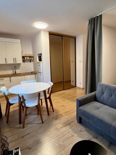 ein Wohnzimmer mit einem Tisch und einem Sofa in der Unterkunft OhMyHome - Hala Mirowska in Warschau