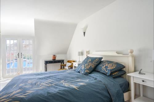 a bedroom with a bed with blue comforter and pillows at Stable Cottage in Bridport