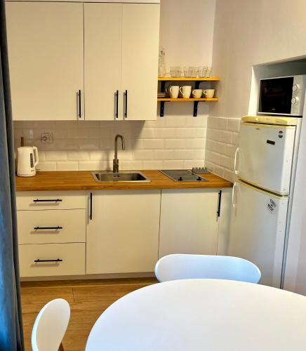 eine Küche mit weißen Schränken und einem weißen Kühlschrank in der Unterkunft OhMyHome - Hala Mirowska in Warschau