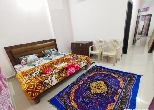 a bedroom with a bed and two carpets on the floor at Deviksha Home Stay in Ujjain