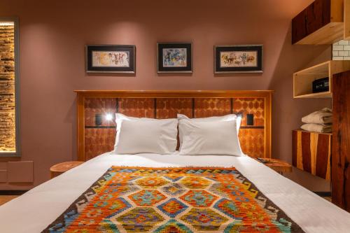 a bedroom with a bed with a colorful rug on it at Vila Origens Boutique Hotel Albufeira – Adults Only in Albufeira