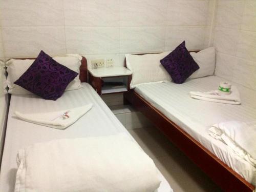 2 posti letto in una camera con asciugamani e tavolo di Relaince Inn a Hong Kong