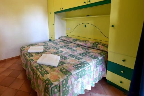 a bedroom with a bed with two towels on it at Hotel Club Torre Capovento in Sperlonga