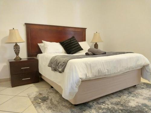 1 dormitorio con 1 cama grande y 2 mesitas de noche en The Emerald, en Pretoria