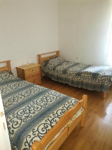 sypialnia z 2 łóżkami i drewnianą podłogą w obiekcie Ορεινή φιλόξενη κατοικια 