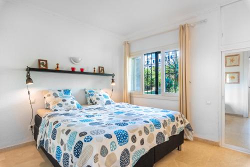1 dormitorio con 1 cama con edredón azul y blanco en Calahonda Beach I Apartment with Sea View en Mijas Costa