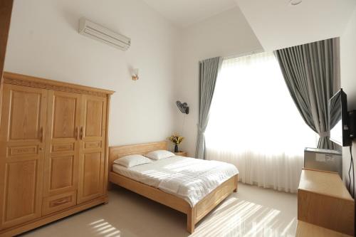 Un dormitorio con una cama y una ventana grande. en Son Ha Hotel, en Vung Tau