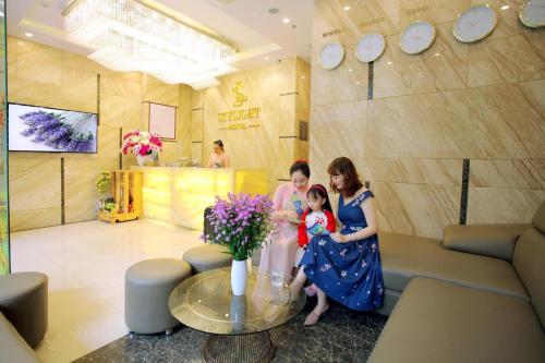 two women and a little girl in a room with flowers at Skylight Hotel Nha Trang in Nha Trang