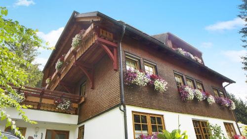 una casa con dei fiori sul lato di Gästehaus Maria Brinkhus a Schonach