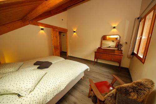 1 dormitorio con cama, tocador y espejo en Chalet les Blancs, en Eygliers