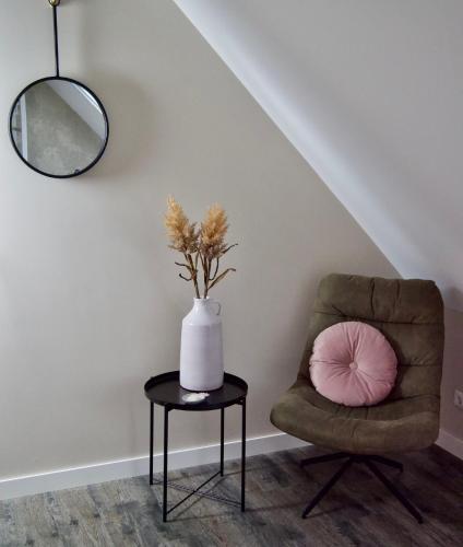 a room with a chair and a vase on a table at La Vita Veluwe in Wapenveld