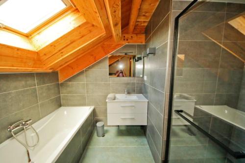 a bathroom with a bath tub and a sink at Chalet les Blancs in Eygliers
