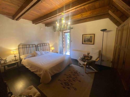 a bedroom with a white bed and a chandelier at Casa TOP para 14 personas en Garós, Ideal esquí in Garós