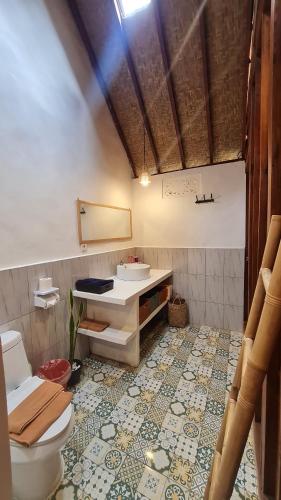 uma casa de banho com um WC e um lavatório em RUMAH KAYU MATARAJA VILLA - TABANAN em Perean