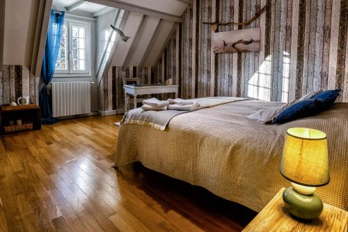 a bedroom with a bed and a table and a lamp at les bois de ravel chambres d'hôtes in Ravel