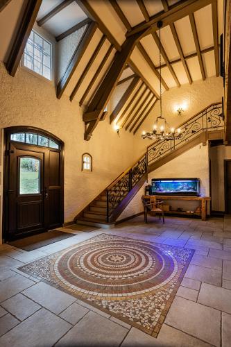 a large room with a staircase and a rug on the floor at les bois de ravel chambres d'hôtes in Ravel