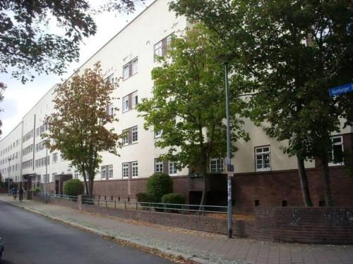 ein großes weißes Gebäude an der Straßenseite in der Unterkunft zentrumsnahes Monteurszimmer in Erfurt