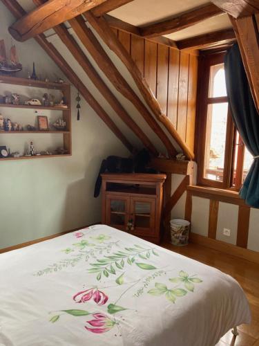 1 Schlafzimmer mit einem Bett mit Blumenbettdecke in der Unterkunft Chambre d'Hôte du Pic Drille in Charmont-sous-Barbuise